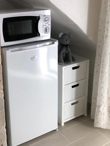 a microwave sitting on top of a refrigerator at Il Dammuso dei Sogni in Modica