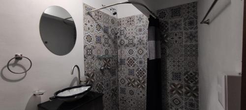 a bathroom with a shower with a mirror and a sink at Leveli Coliving in Guadalajara