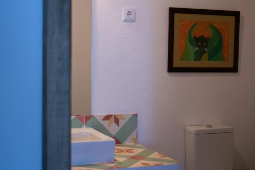a bathroom with a toilet and a painting of a cat at Quinta de SantAna da Várzea in Abrantes