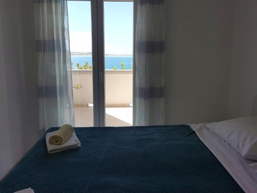 Schlafzimmer mit einem Bett und Meerblick in der Unterkunft Apartments Near Sea in Metajna