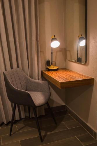 a desk with a chair and a mirror and a lamp at Hotel Boutique Corazón Mexicano in Guanajuato