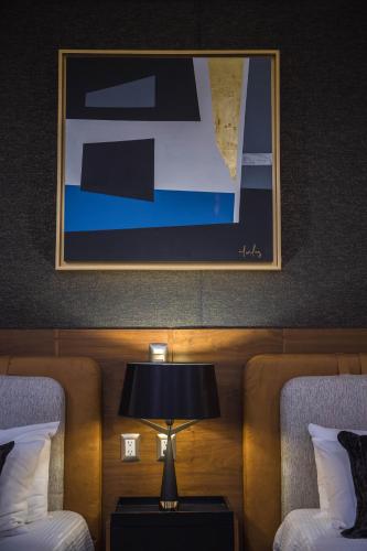 a lamp on a table in a hotel room with two beds at Hotel Boutique Corazón Mexicano in Guanajuato