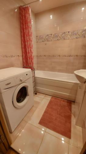 a bathroom with a washing machine and a bath tub at Celtnieku 14 in Ventspils