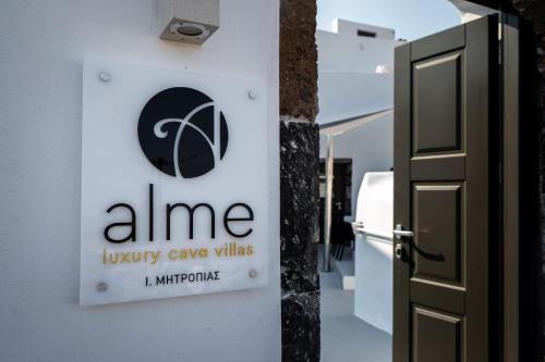 a sign for aine luxury cave villas on a wall next to a door at Alme Luxury Cave Villas in Vóthon