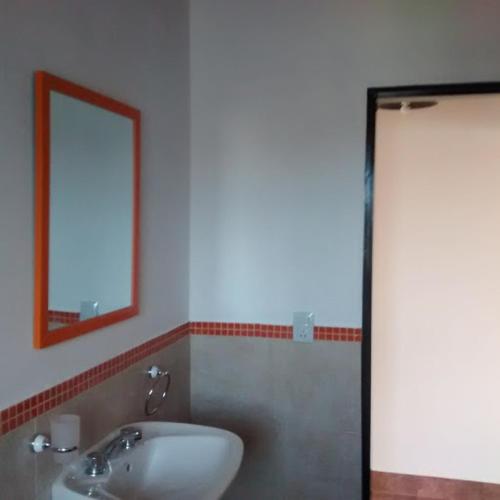 a bathroom with a sink and a mirror at Departamento Estancia Vieja 74 PA in Estancia Vieja