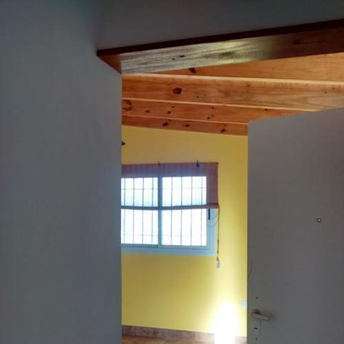 una camera con finestra in una stanza con pareti gialle di Departamento Estancia Vieja 74 PA a Estancia Vieja