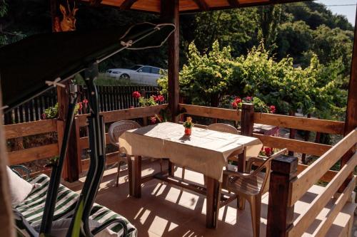 a table and chairs on the deck of a house at Apartmani Ružina staza in Rudnik Kačerski