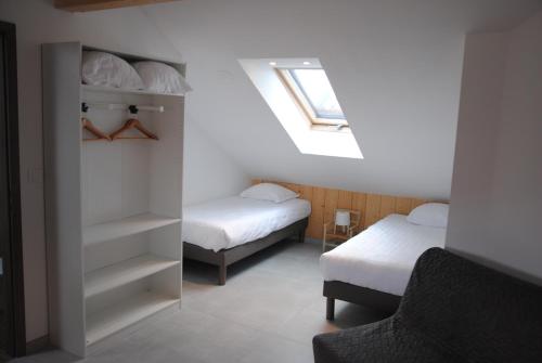 a small room with two beds and a window at Suites Conviviales la Vignette in Benfeld