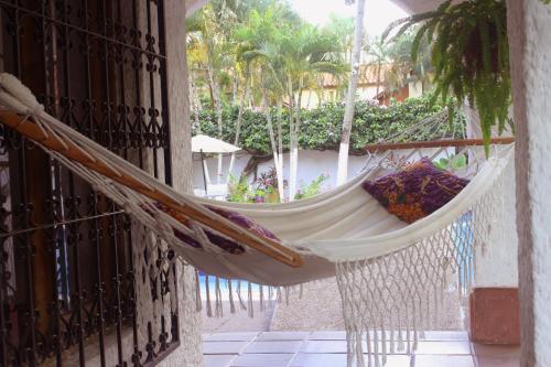 a hammock hanging on a balcony with a building at Casa Campestre Villa Margarita in Honda