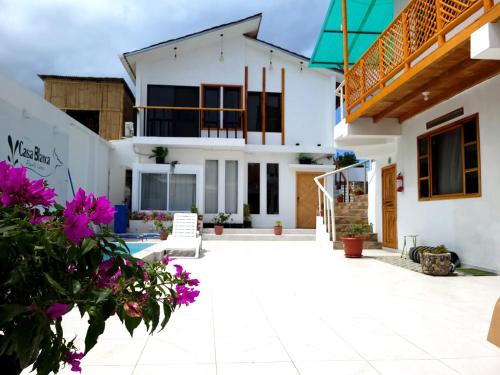 a house with a courtyard with purple flowers at Casa Blanca Suites in Puerto López