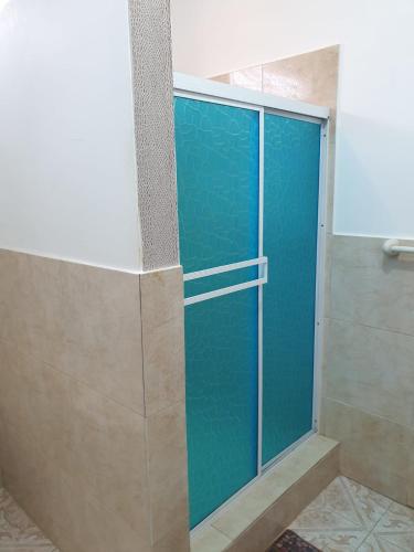a shower with blue glass doors in a bathroom at Casa Blanca Suites in Puerto López