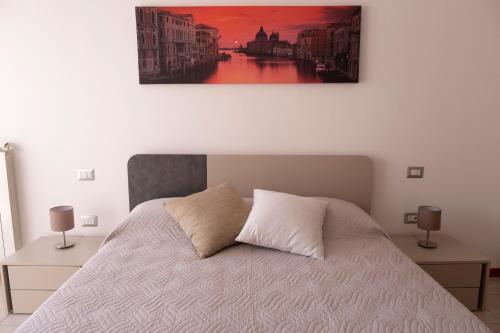 a bedroom with a bed and a painting on the wall at Sky Sun & Sea in Cavallino-Treporti