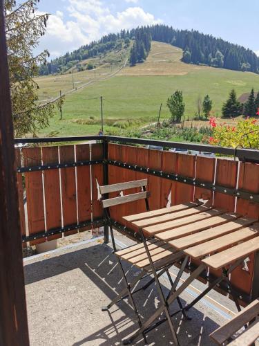 a wooden bench sitting on top of a balcony at Hôtel Au Feu De Bois in Autrans
