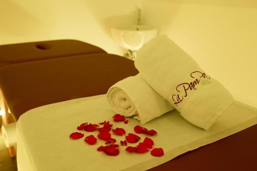 a hotel room with a towel and roses on a bed at La Pampa Relais & Spa in Melizzano