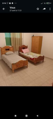 two beds are sitting in a room at Appartement in Taza
