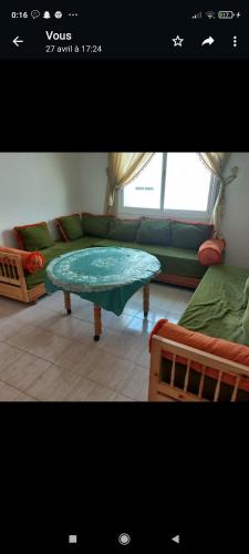 a living room with a couch and a glass table at Appartement in Taza