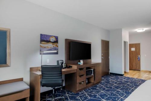 a hotel room with a desk with a tv and a chair at Best Western Plus St. Louis Airport Hotel in Saint Louis