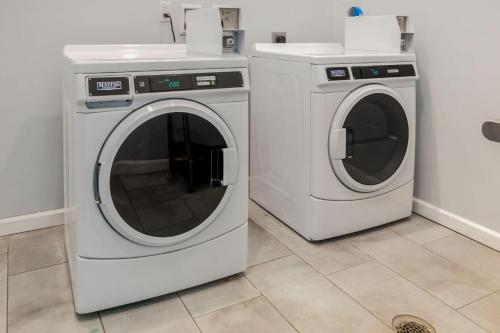 two washing machines and a sink in a room at Best Western Plus St. Louis Airport Hotel in Saint Louis
