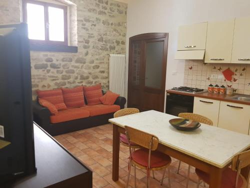 een woonkamer met een bank en een tafel bij Casale in collina vista Assisi,Brufa di Torgiano in Brufa