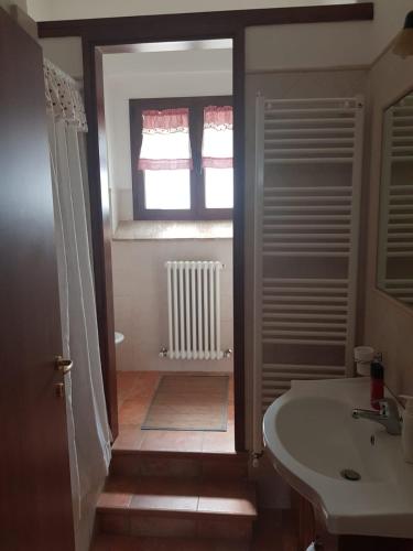 a bathroom with a sink and a toilet and a window at Casale in collina vista Assisi,Brufa di Torgiano in Brufa
