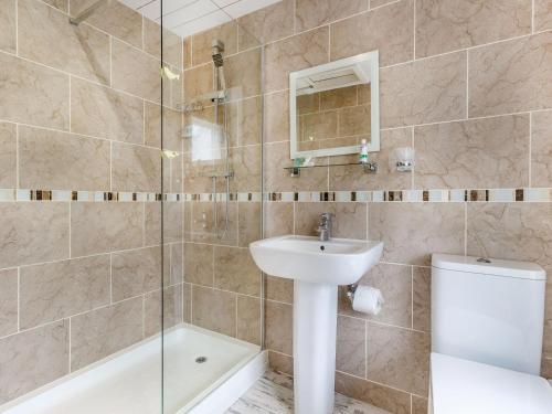 ein Badezimmer mit Waschbecken, Toilette und Dusche in der Unterkunft Magnolia Cottage in Barton