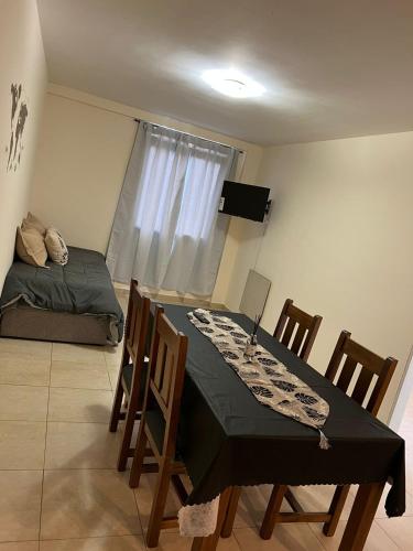 a dining room with a table and chairs and a bed at Departamentos Hipolito Yrigoyen in San Rafael