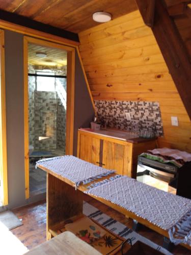 Habitación con cocina en una cabaña de madera en Suites da Dorinha en Visconde De Maua