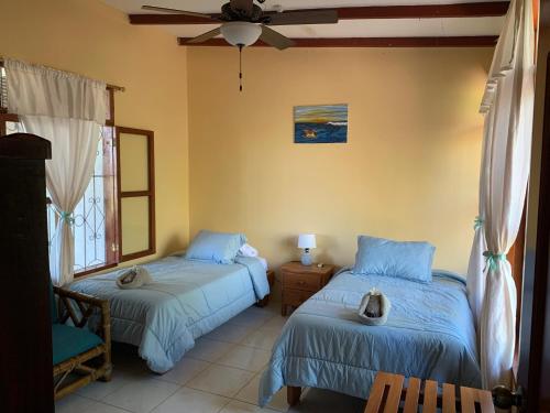 a bedroom with two beds and a ceiling fan at Casa Verde Vacation Garden Home in San Cristobal