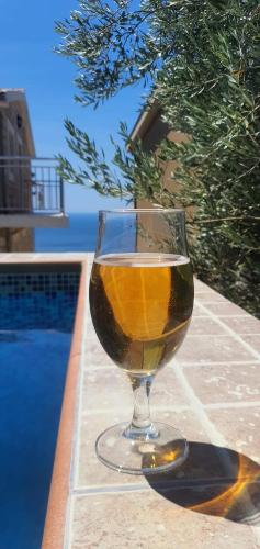 a glass of wine sitting next to a swimming pool at Apartments Dragišić in Sveti Stefan