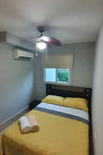 Un dormitorio con una cama amarilla y una ventana en R.1109 Estudio ejecutivo., en Panamá