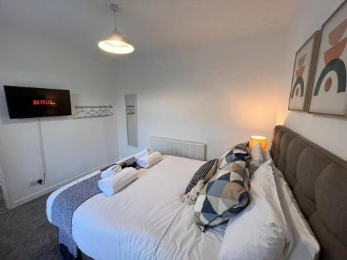 a bed in a room with a tv on the wall at Bridge Place - Spacious home with plenty of beds! in Merthyr Tydfil