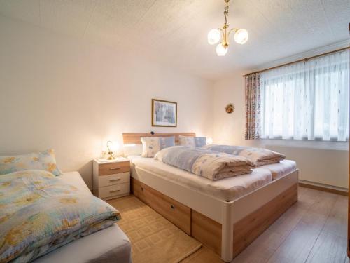 1 dormitorio con 2 camas y ventana en Apartment Claudia en Vandans