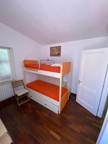 a bedroom with two bunk beds and a chair at Appartamento esclusivo nella piazza di Numana in Numana