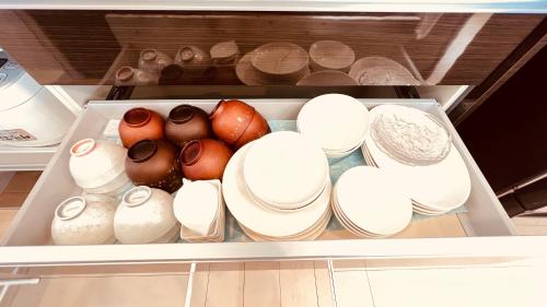 a refrigerator filled with lots of white bowls and vases at Blue Ocean in Inbu