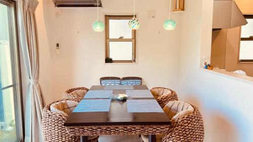 jadalnia z drewnianym stołem i wiklinowymi krzesłami w obiekcie BlueOcean恩納村 w mieście Inbu