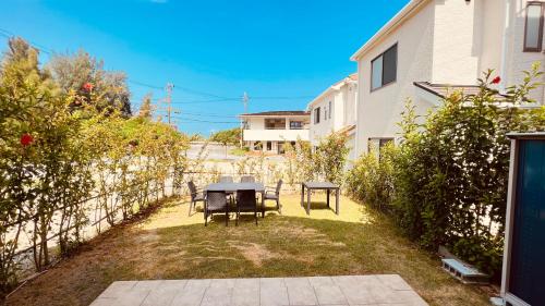 a patio with a table and chairs in a yard at Blue Ocean in Inbu