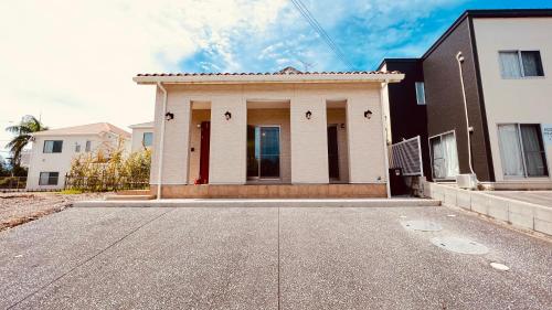 a white house with red doors on a street at Blue Ocean in Inbu