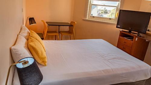 a bedroom with a bed and a television and a table at Hotel Renmark in Renmark
