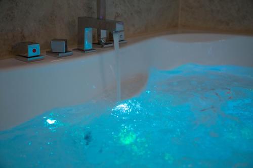 a bathroom with a bath tub with blue water at Alpha & Omega Hotel in Stuttgart