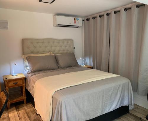 a bedroom with a large bed with a white bedspread at Estúdio no Condomínio Acquaville in Ilhabela