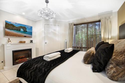 a bedroom with a large bed and a fireplace at Villa 3 By The Sea in Coffs Harbour