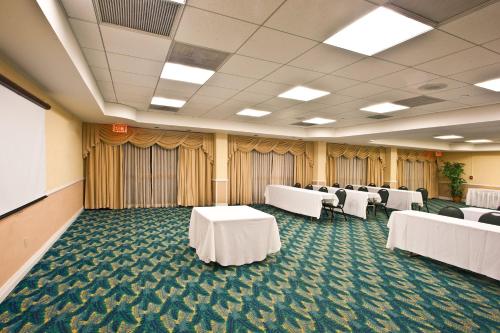 a conference room with white tables and chairs in it at Holiday Inn Port St. Lucie by IHG in Port Saint Lucie