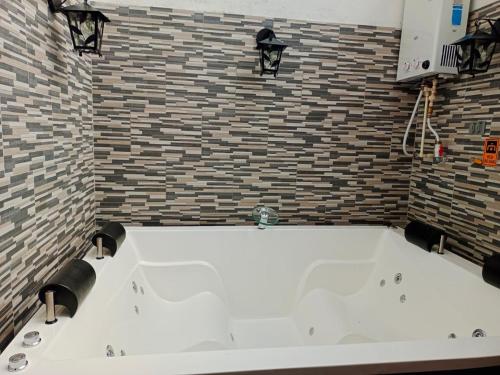 a large white tub in a bathroom with a brick wall at Apartamento turístico jardín Antioquia in Jardin