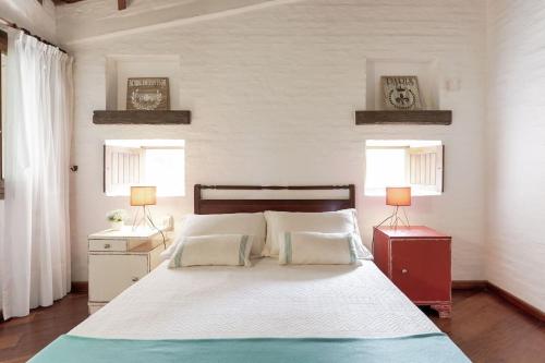 a bedroom with a large bed with two lamps at Posada del Huerto in La Carrodilla