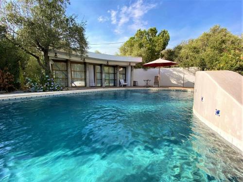 a swimming pool with blue water in front of a house at Belvilla by OYO Cortijo de Santa Cruz in Órgiva