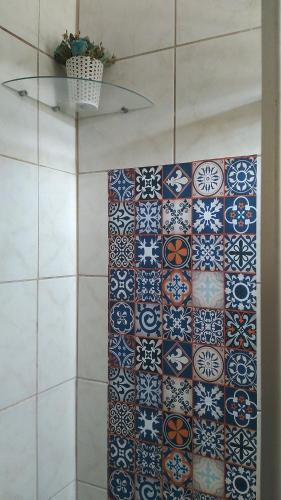 uma casa de banho com uma parede em azulejo e um monte de azulejos. em Hospedaria Ilhéus 04 em Ilhéus