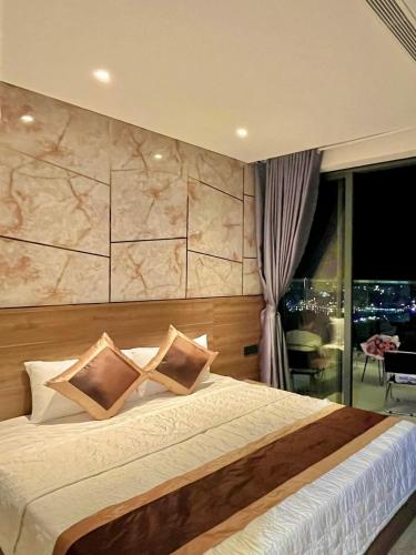a bedroom with a large bed and a large window at Apec Mandala Tuy Hòa Phú Yên Tina House in Ðông Tác (1)