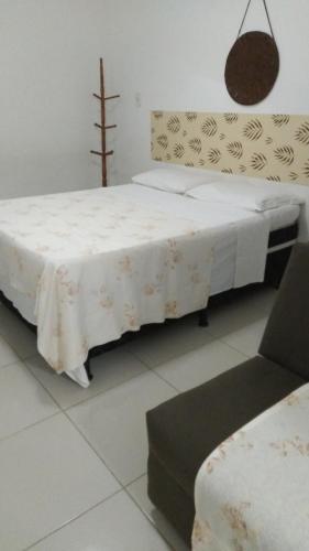 a bedroom with a bed with a table and a chair at Hospedaria Ilhéus 01 in Ilhéus