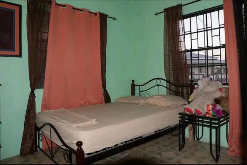 un dormitorio con una cama con un animal de peluche en Altare - Breezy with a View en Grand Anse