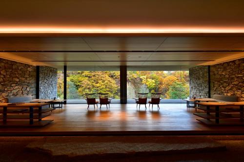 a room with tables and chairs and a large window at Chalet Ivy Jozankei in Jozankei